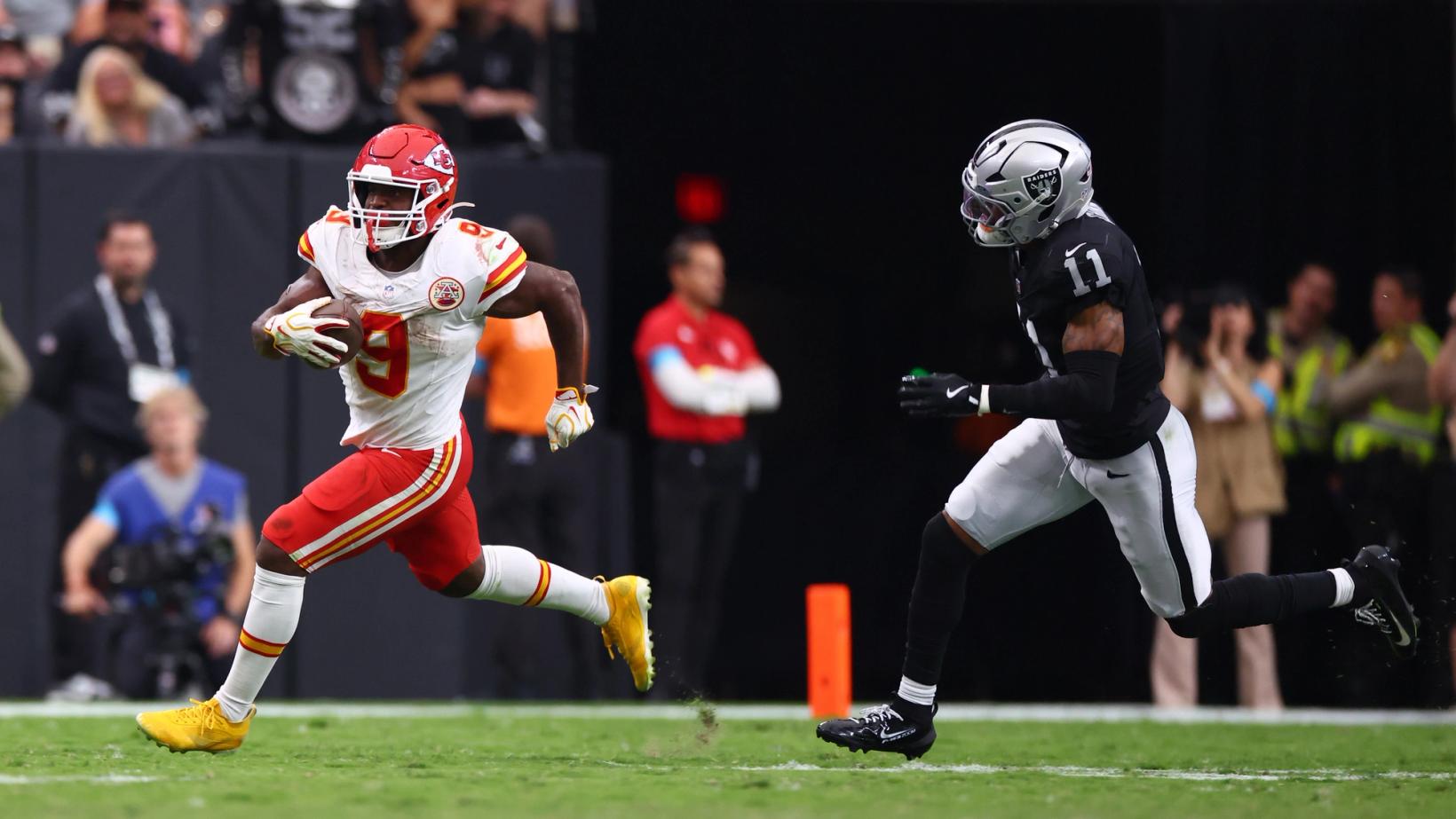 Kansas City Chiefs running back Kenneth Walker III (9) runs with the ball along the sideline as a Las Vegas Raiders defender gives chase at Allegiant Stadium.