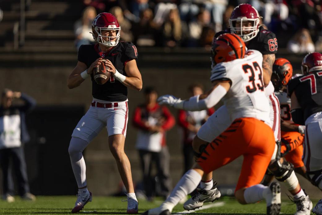 Harvard quarterback Charlie Smith, No. 14 in black, sets to throw as a Princeton defender is held up during Harvard's 35-7 win over Princeton at Harvard Stadium on Oct. 24, 2026