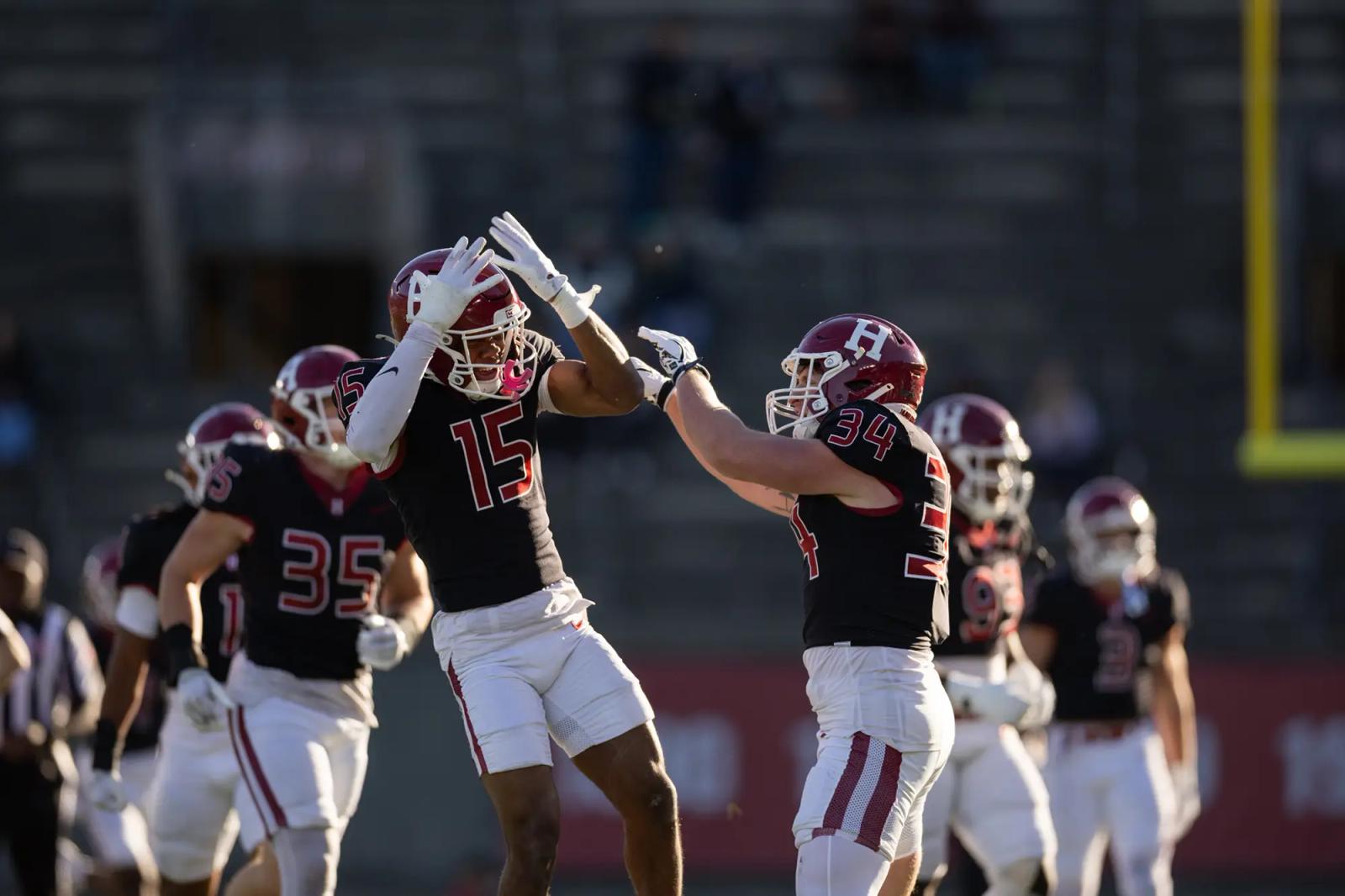 Harvard's Benson and Benefield celebrate during the Crimson's 35-7 win over Princeton on Oct. 24, 2026.