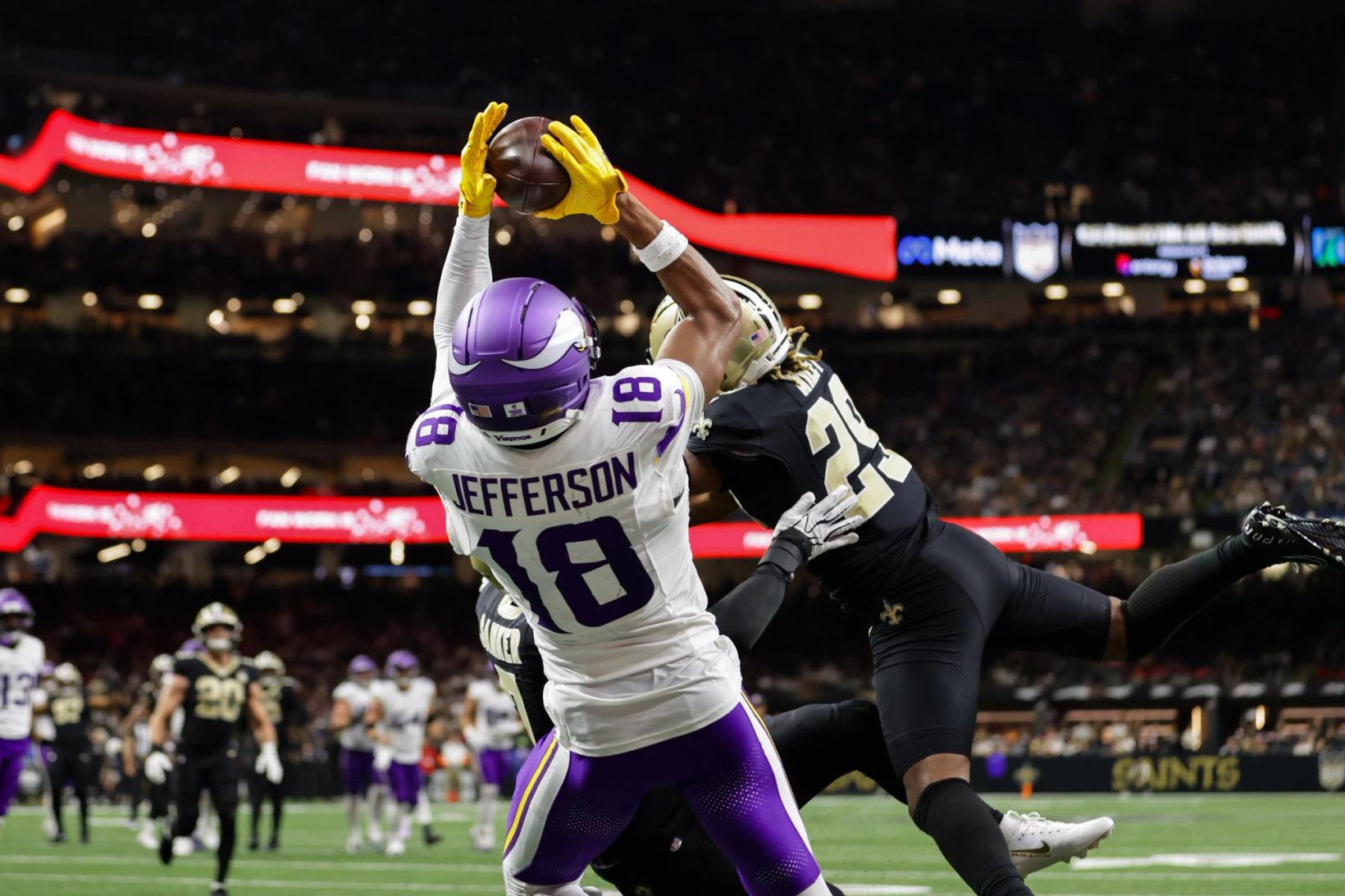 Minnesota Vikings wide receiver Justin Jefferson (18) catches a high pass over a leaping New Orleans Saints defender at Caesars Superdome.
