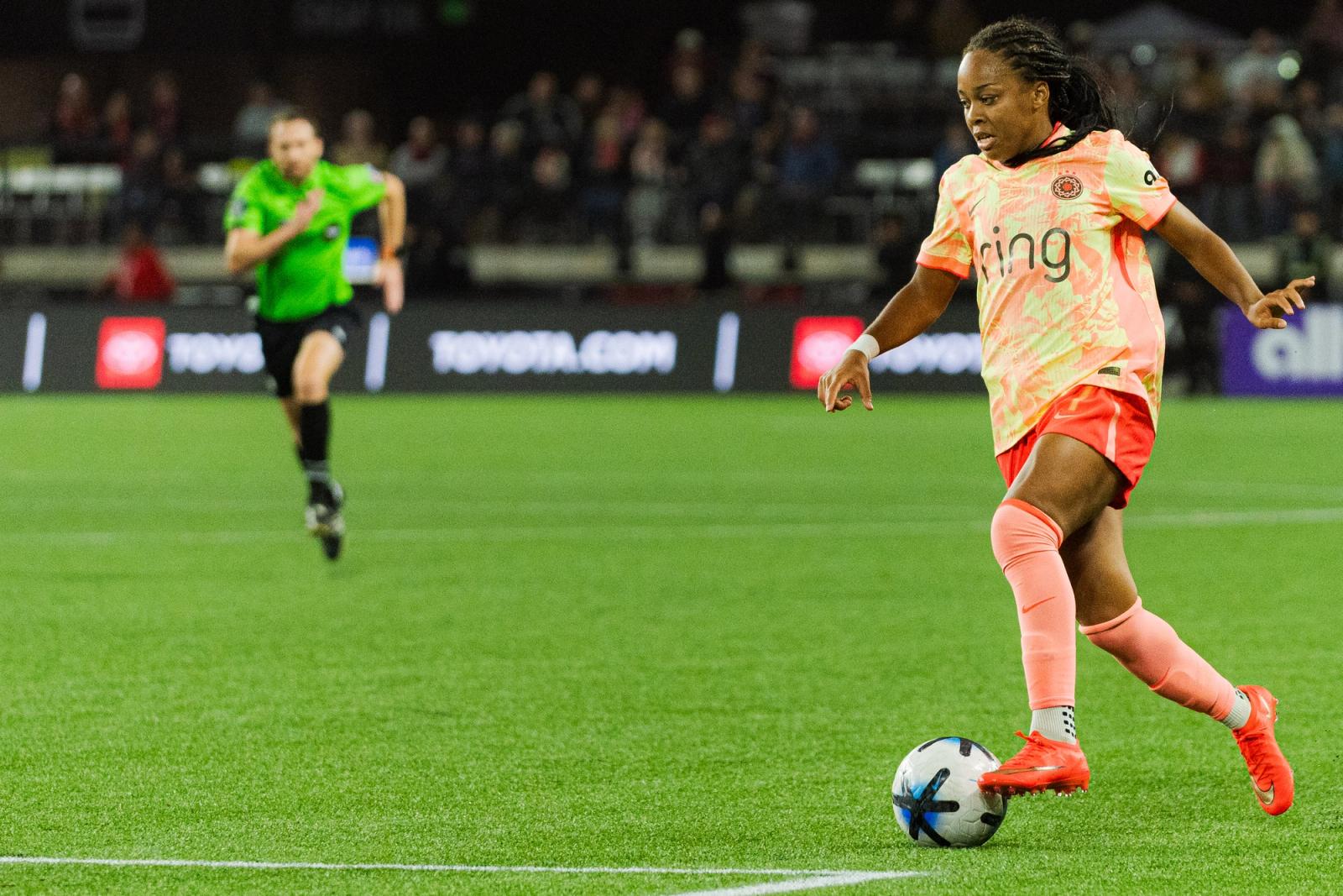 Houston Dash player dribbles under stadium lights at Providence Park — Photo Credit: Aaron Leopold/Undrafted