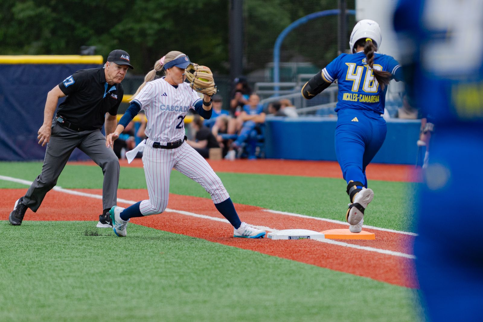 A Portland Cascade runner and an Oklahoma City Spark fielder converge at the base as an umpire watches during the June 21, 2026 game at Hillsboro Ballpark in Hillsboro, Oregon.