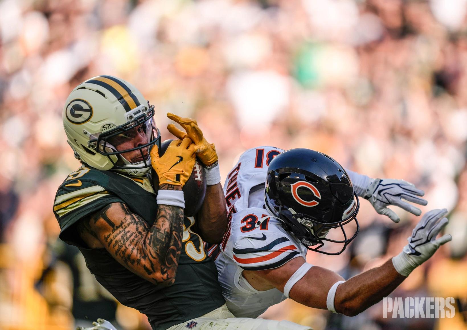 A Green Bay Packers receiver secures a catch as Chicago Bears safety Dillon Thieneman (31) defends from behind at Lambeau Field