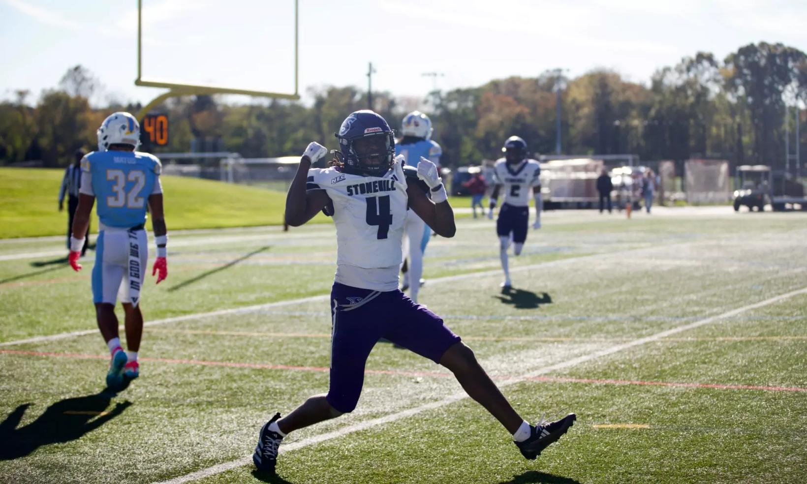 Stonehill receiver Jaylin Baker, wearing No. 4 in a white jersey, celebrates on the field at LIU as an LIU defender in light blue walks away on Oct. 24, 2026