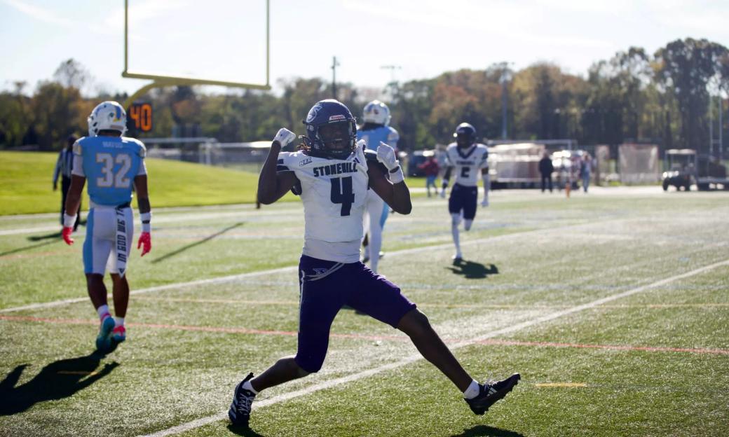 Stonehill receiver Jaylin Baker, wearing No. 4 in a white jersey, celebrates on the field at LIU as an LIU defender in light blue walks away on Oct. 24, 2026