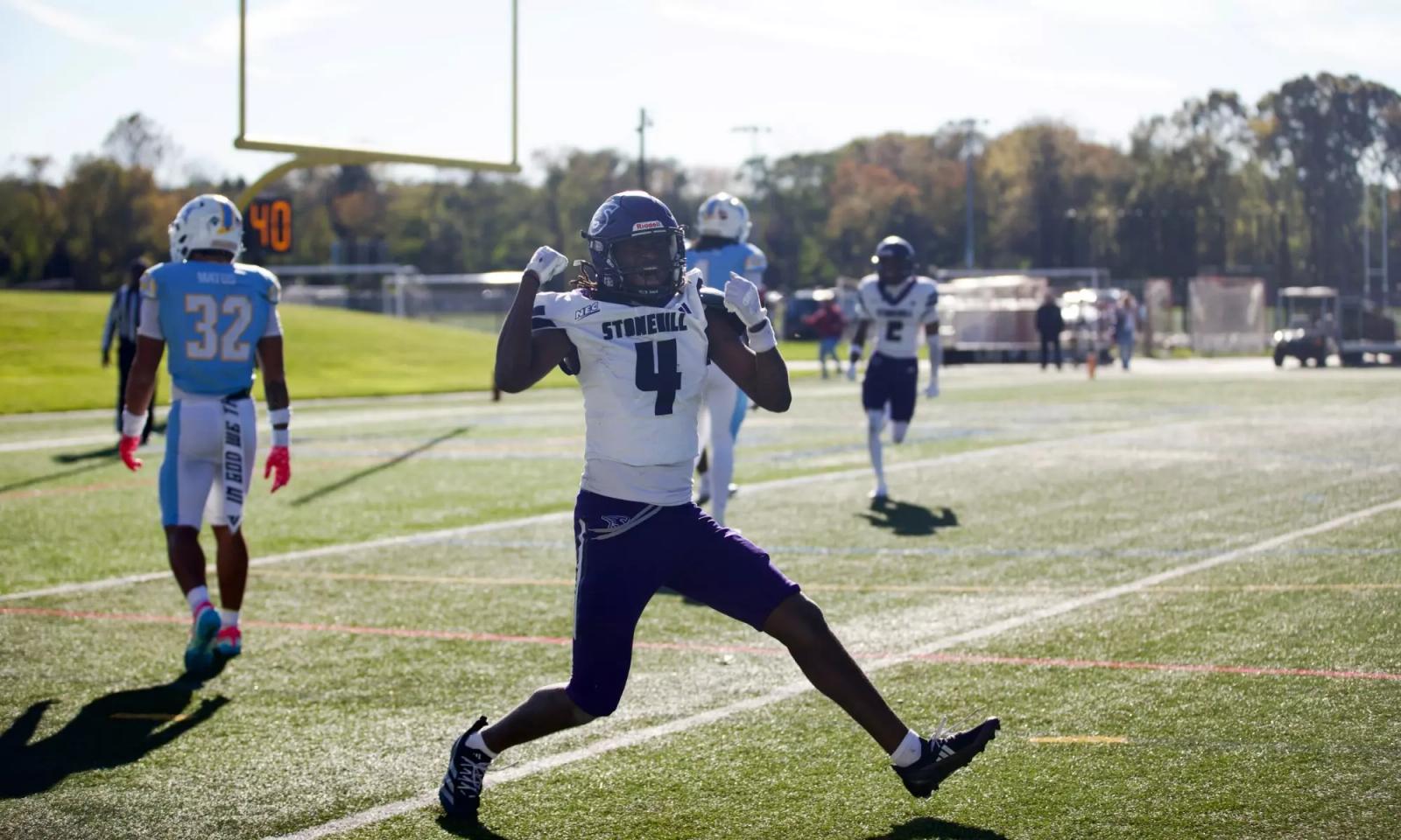 Stonehill receiver Jaylin Baker, wearing No. 4 in a white jersey, celebrates on the field at LIU as an LIU defender in light blue walks away on Oct. 24, 2026