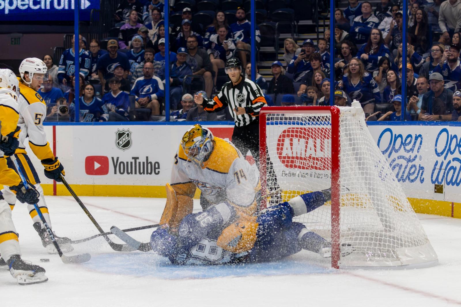 Lightning player and Predators goalie collide in a spray of ice — Photo Credit: Samantha Diane/Undrafted