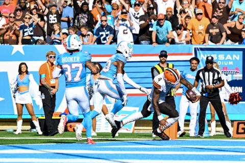 Cleveland Browns quarterback Deshaun Watson (4) reaches the football toward the pylon as two Tennessee Titans defenders chase him in front of the stands at Nissan Stadium.