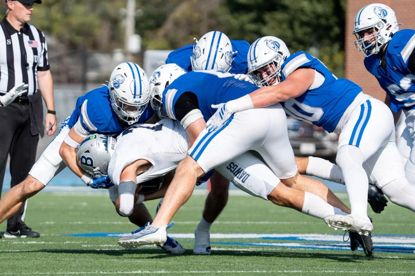 Drake defenders in blue jerseys and white helmets gang-tackle a Butler ball carrier during a home game earlier this season (file photo).