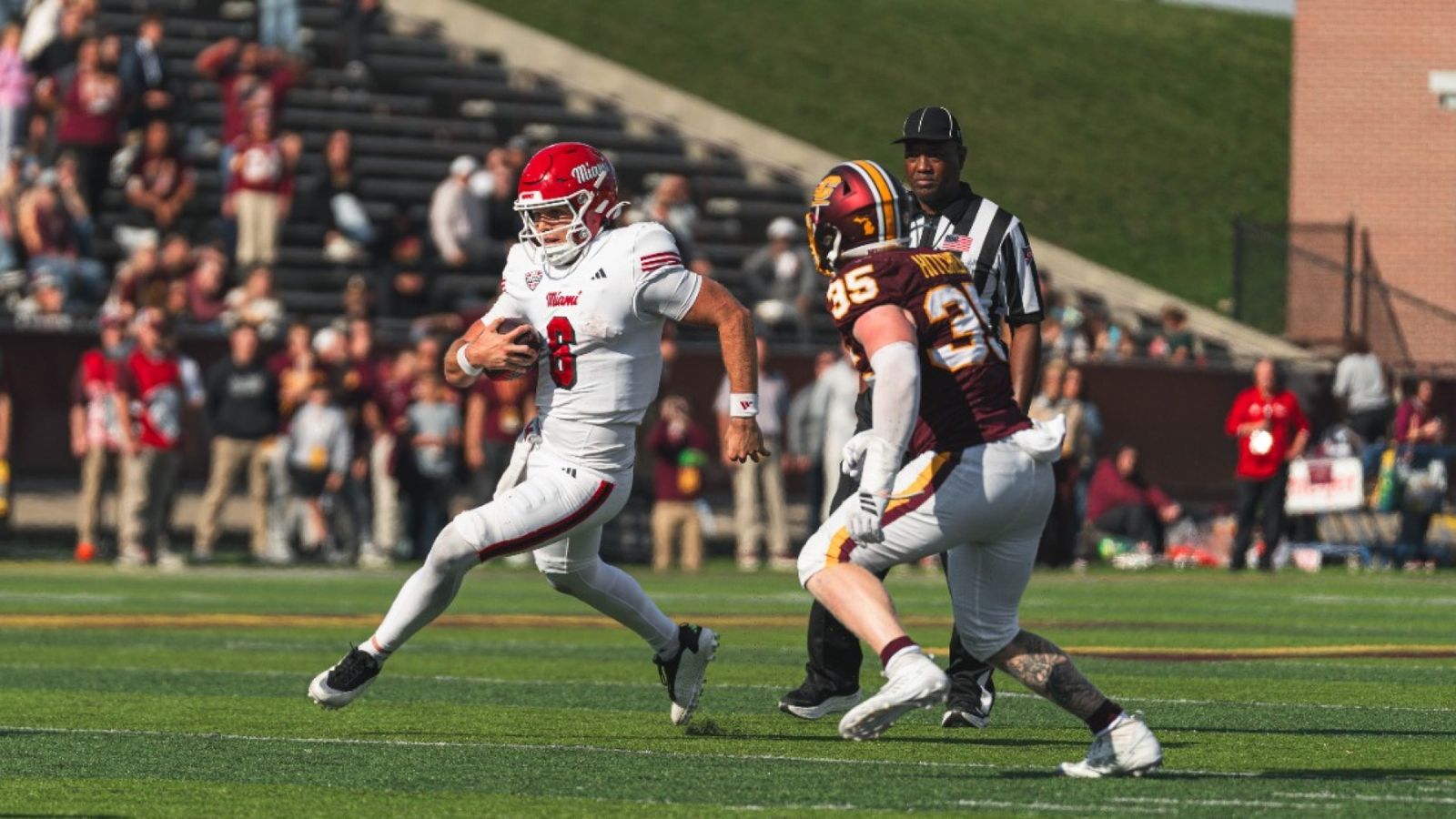 Miami (OH) No. 8 in a white uniform carries the ball past a Central Michigan defender at Kelly/Shorts Stadium during Miami's 28-27 win on Oct. 24, 2026