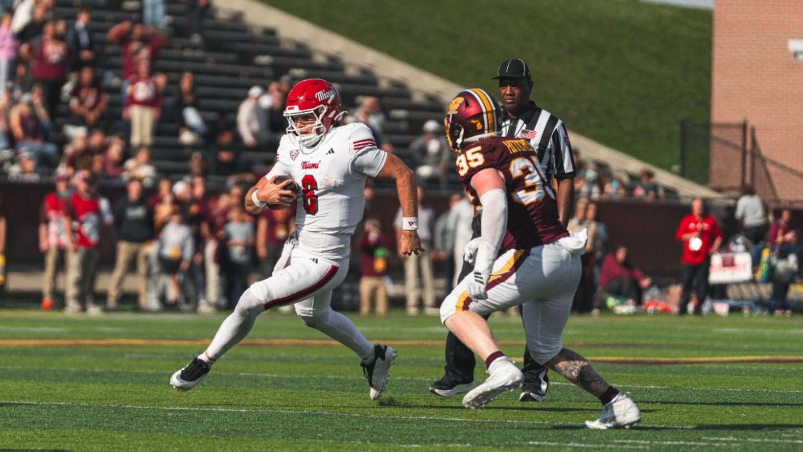 Miami (OH) No. 8 in a white uniform carries the ball past a Central Michigan defender at Kelly/Shorts Stadium during Miami's 28-27 win on Oct. 24, 2026