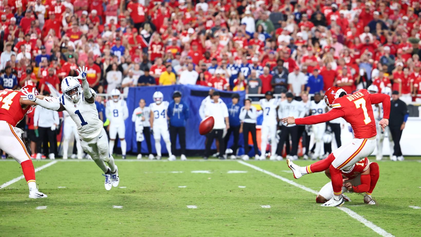 Kansas City Chiefs kicker Harrison Butker (7) kicks a field goal off the hold as Indianapolis Colts defender Sauce Gardner (1) dives from the edge at Arrowhead Stadium