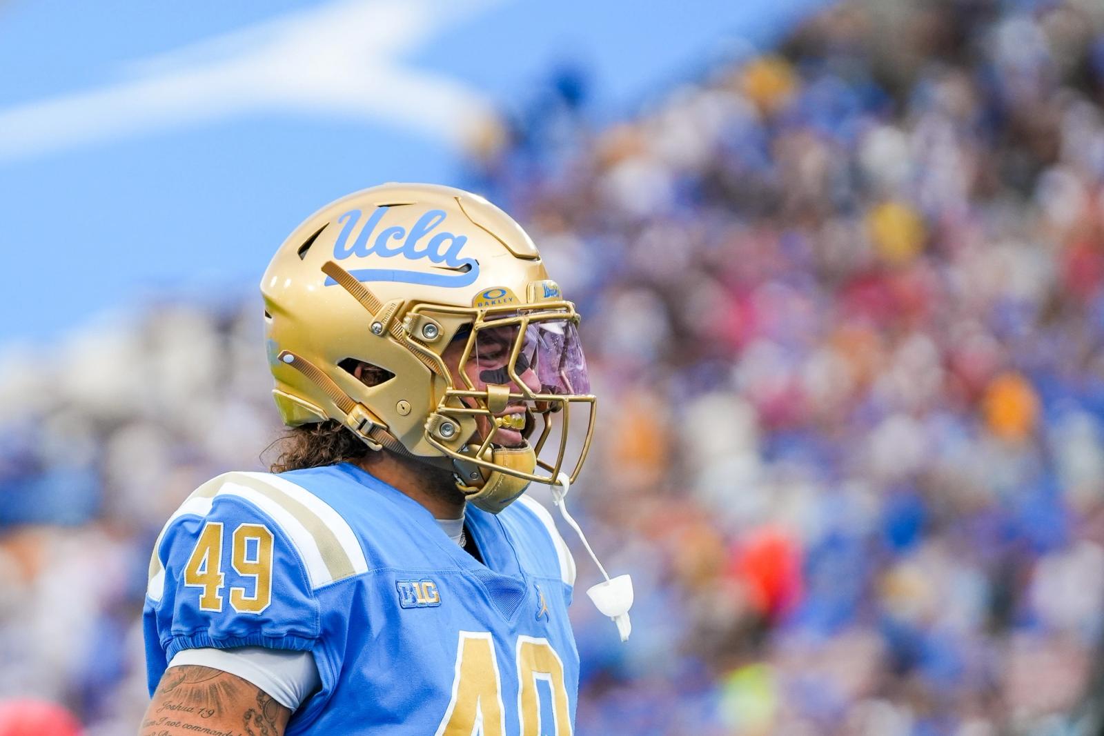 UCLA player in gold helmet and blue jersey at the Rose Bowl during the Wisconsin game