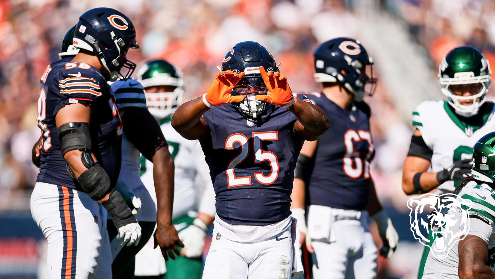 Chicago Bears running back Kyle Monangai (25) holds both hands up in front of his face mask as teammates and New York Jets players stand nearby.