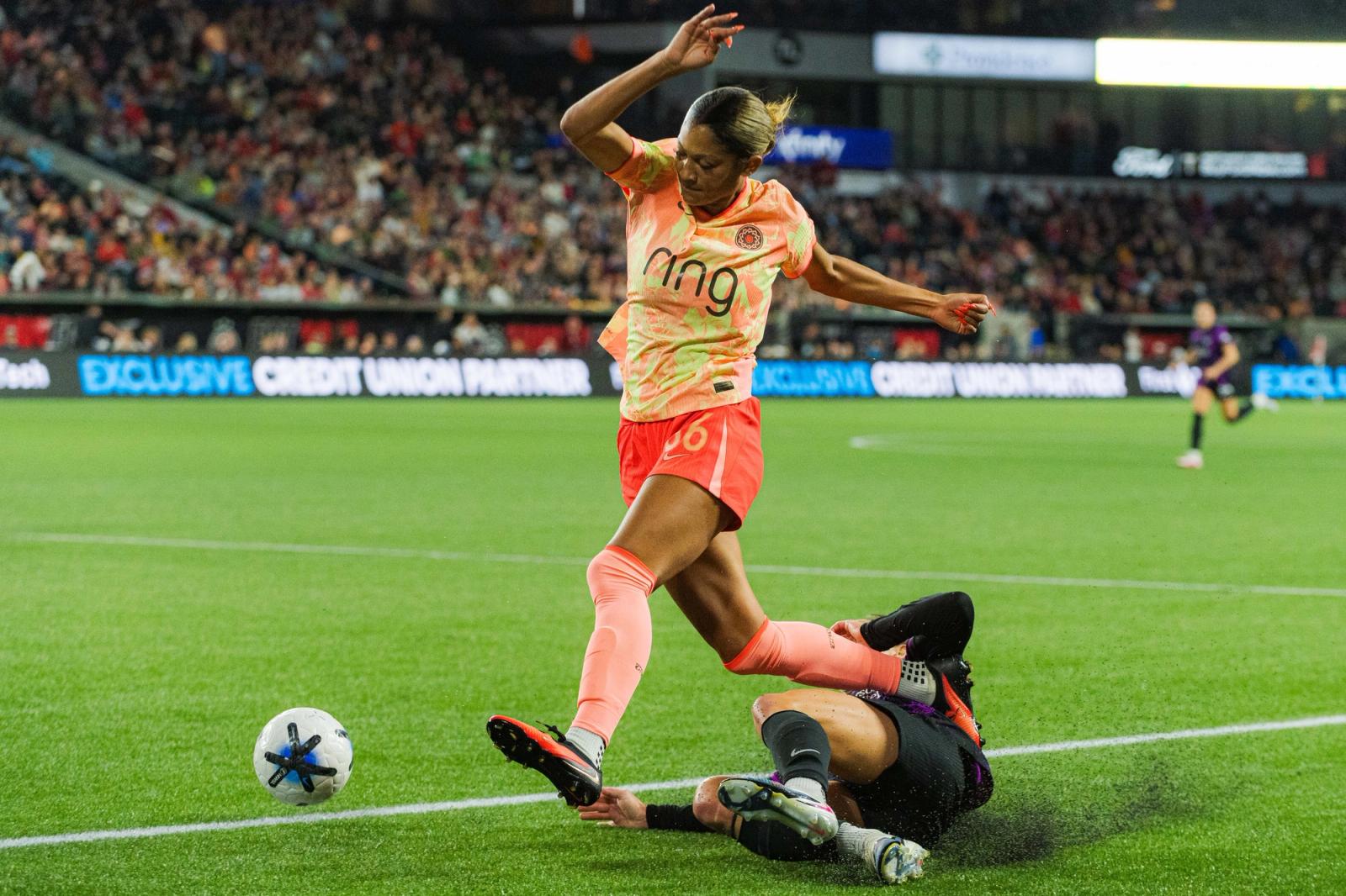 Houston Dash player dribbles past a sliding tackle at Providence Park — Photo Credit: Aaron Leopold/Undrafted