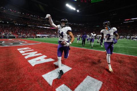 Baltimore Ravens safety Kyle Hamilton (14) holds the ball and gestures in the end zone as cornerback Nate Wiggins (2) and teammates run onto the field at Mercedes-Benz Stadium