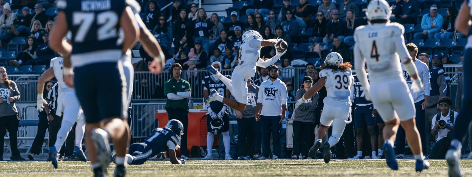 A San Jose State defender in white leaps to grab the ball in front of the Nevada sideline at Mackay Stadium during Nevada's 28-13 win over the Spartans on Oct. 24, 2026