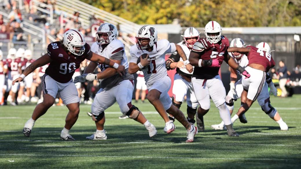 A Lafayette ball carrier in white (No. 11) runs behind his blockers as Fordham defenders in maroon pursue during the Leopards' 31-17 win at Fordham's Jack Coffey Field in the Bronx on October 24, 2026.