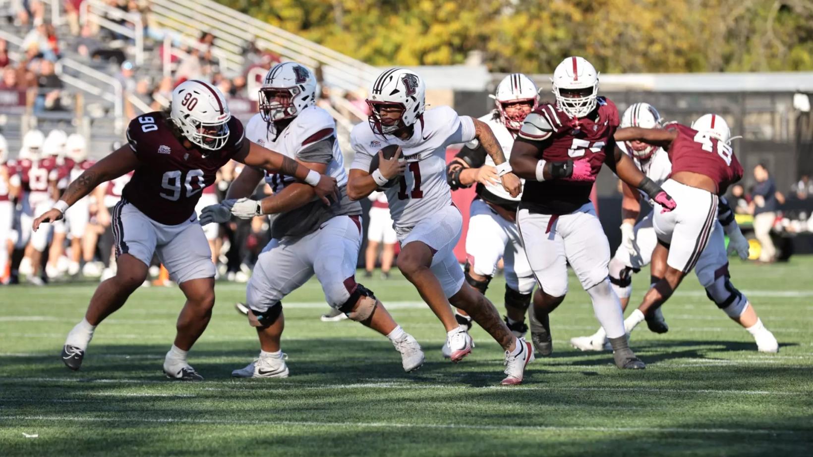 A Lafayette ball carrier in white (No. 11) runs behind his blockers as Fordham defenders in maroon pursue during the Leopards' 31-17 win at Fordham's Jack Coffey Field in the Bronx on October 24, 2026.