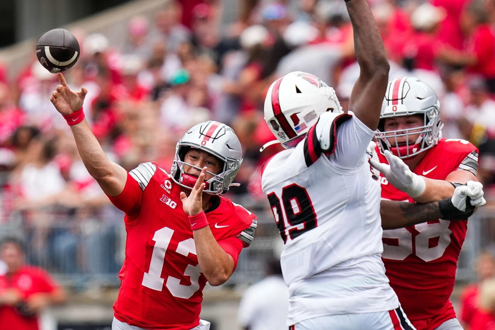 Ohio State quarterback Luke Fahey, No. 13, throws a pass as offensive lineman Gabe Vansickle blocks against Ball State at Ohio Stadium.