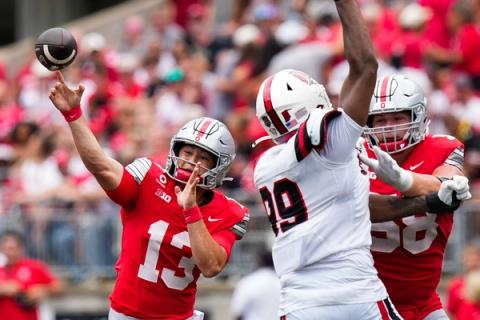 Ohio State quarterback Luke Fahey, No. 13, throws a pass as offensive lineman Gabe Vansickle blocks against Ball State at Ohio Stadium.