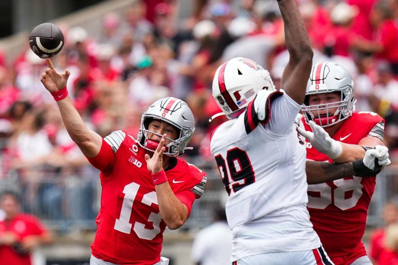 Ohio State quarterback Luke Fahey, No. 13, throws a pass as offensive lineman Gabe Vansickle blocks against Ball State at Ohio Stadium.