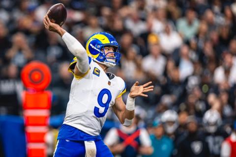 Los Angeles Rams quarterback Matthew Stafford (9) winds up to throw a pass with a crowd behind him at Allegiant Stadium.