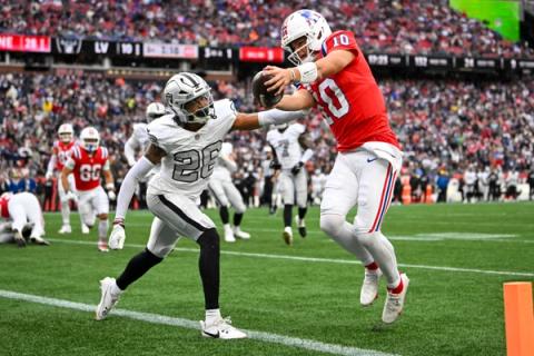 New England Patriots quarterback Drake Maye (10) reaches the ball toward the pylon as Las Vegas Raiders defender Darien Porter (26) closes in at Gillette Stadium.