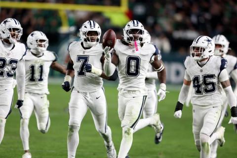 Dallas Cowboys linebacker DeMarvion Overshown (0) carries the football as teammates in white jerseys run alongside him at Lincoln Financial Field.