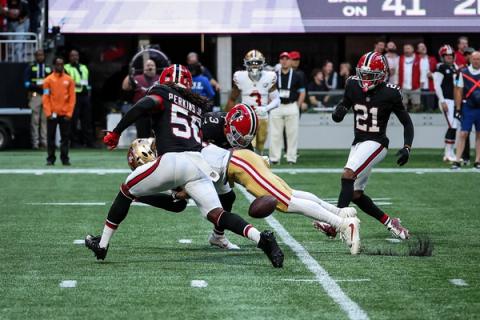 Atlanta Falcons linebacker Harold Perkins Jr. (56) and safety Jessie Bates III (3) hit a San Francisco 49ers ball carrier as the football comes loose, with another Falcons defender closing in.