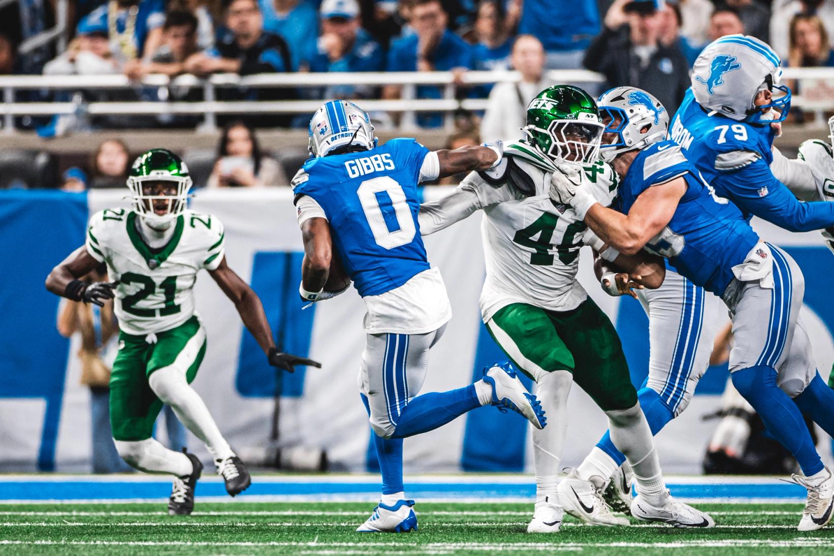 Detroit Lions running back Jahmyr Gibbs (0) carries the ball as Lions blockers engage New York Jets defenders at Ford Field