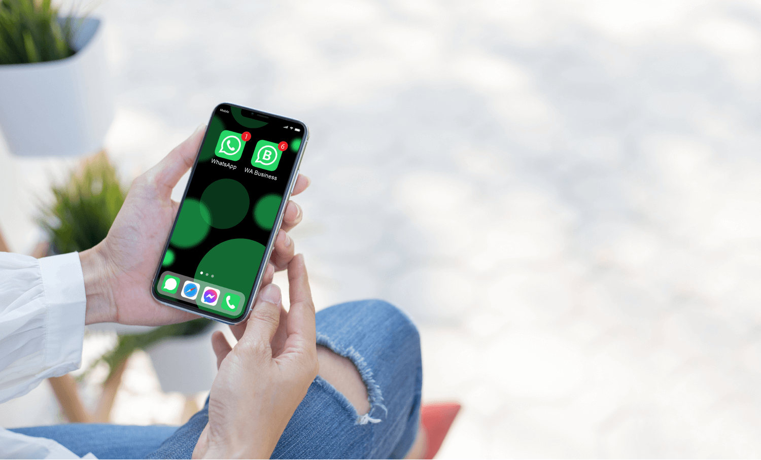 Female hands holding a phone with WhatsApp and WhatsApp Business installed on it