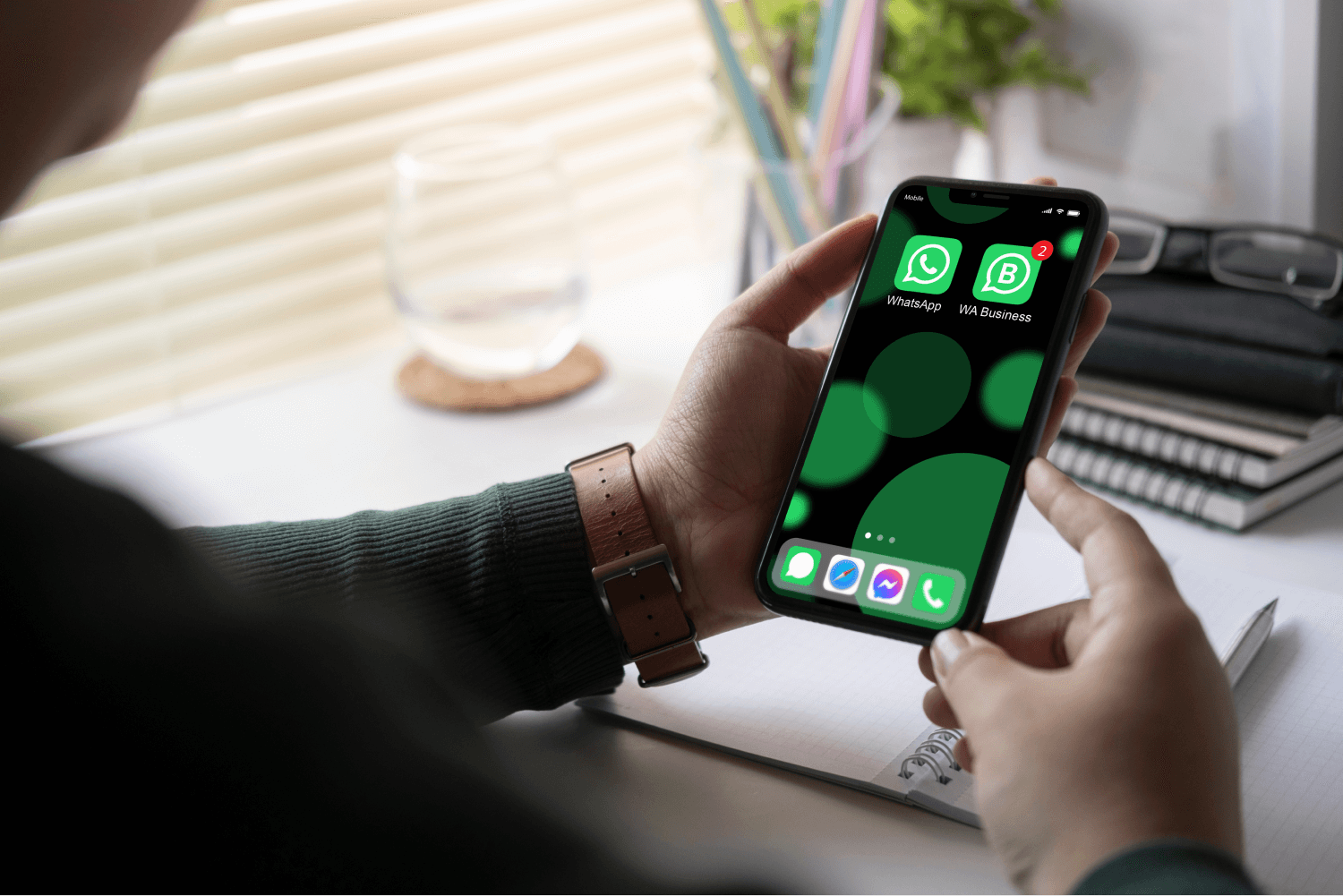 hands holding a phone with WhatsApp and WhatsApp Business installed on it