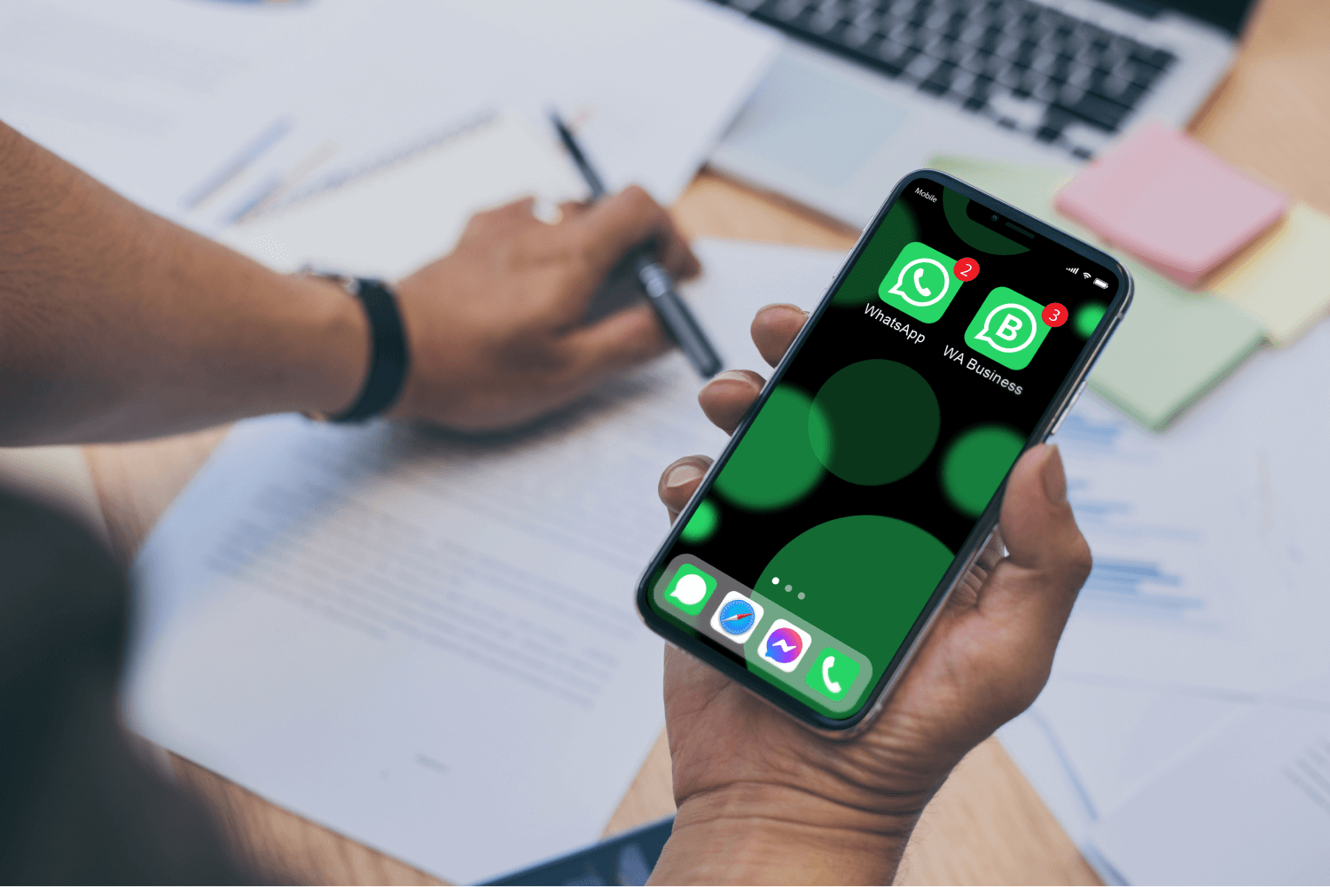 office worker hands holding a phone with WhatsApp and WhatsApp Business installed on it
