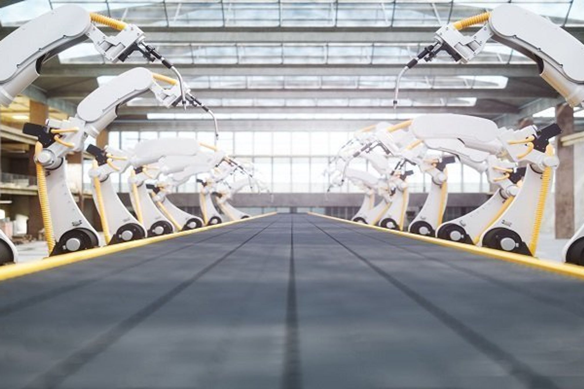 Interior of a modern automated factory with robotic arms and conveyor belt.