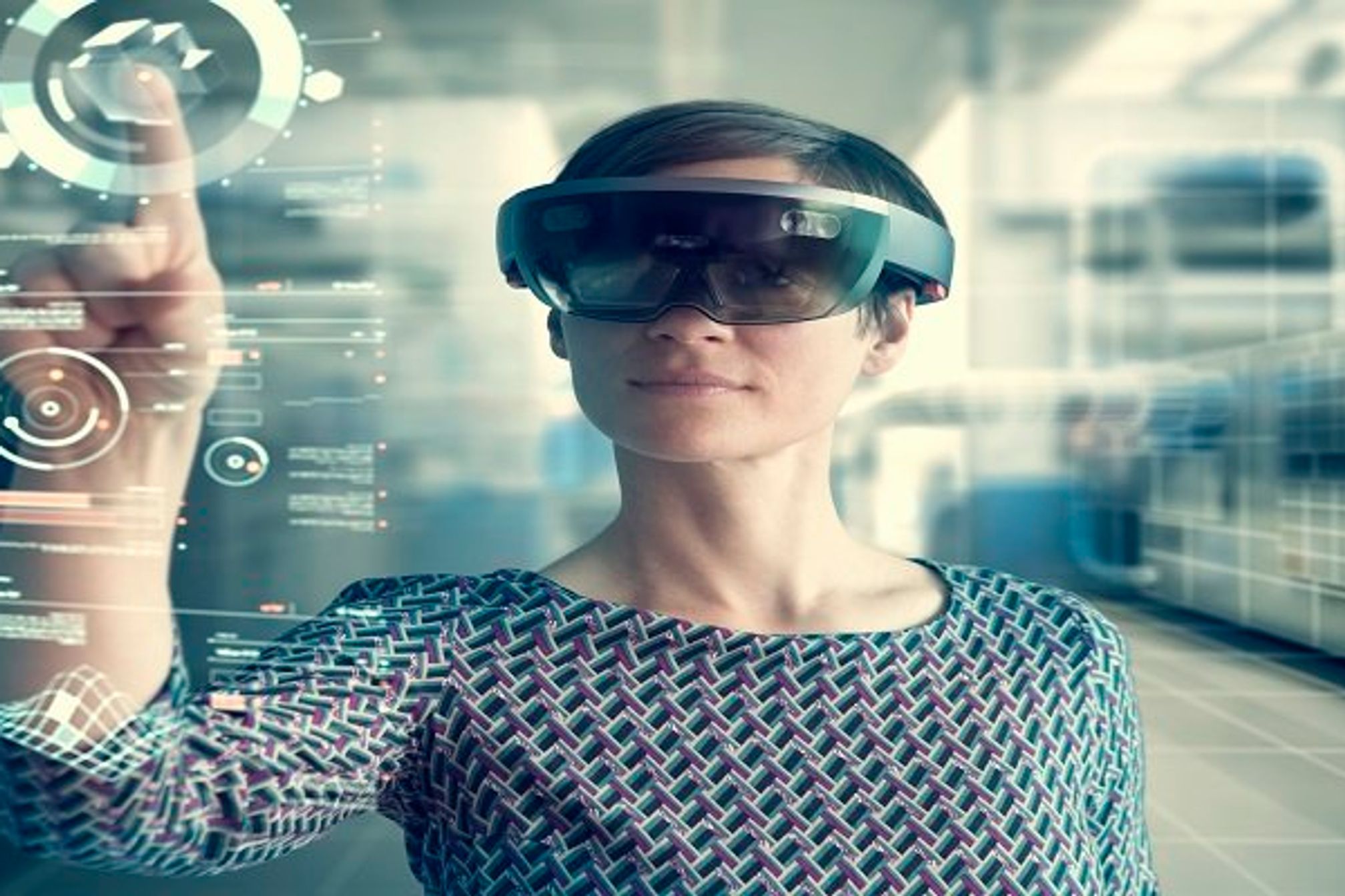 Woman wearing mixed reality smartglasses touching transparent screen