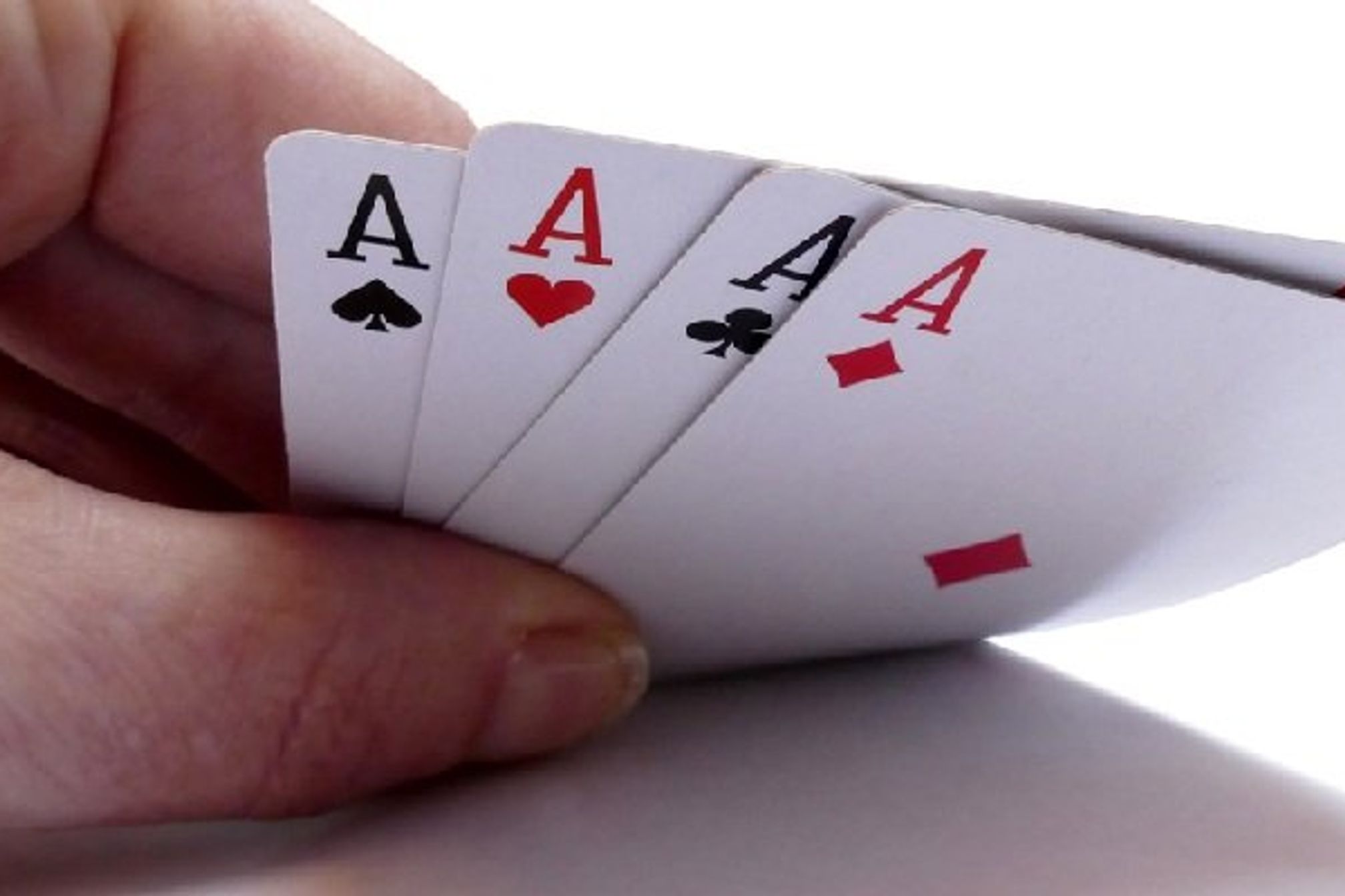 Hand lifting up 4 aces cards isolated on white