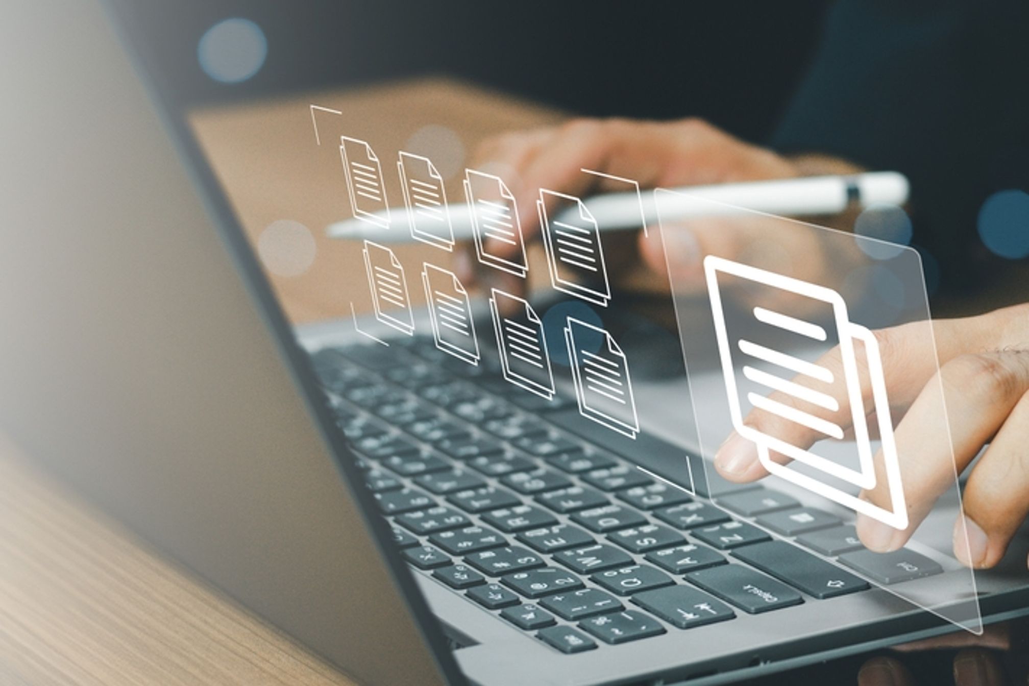 Person using a laptop with graphics of files overlaid on screen