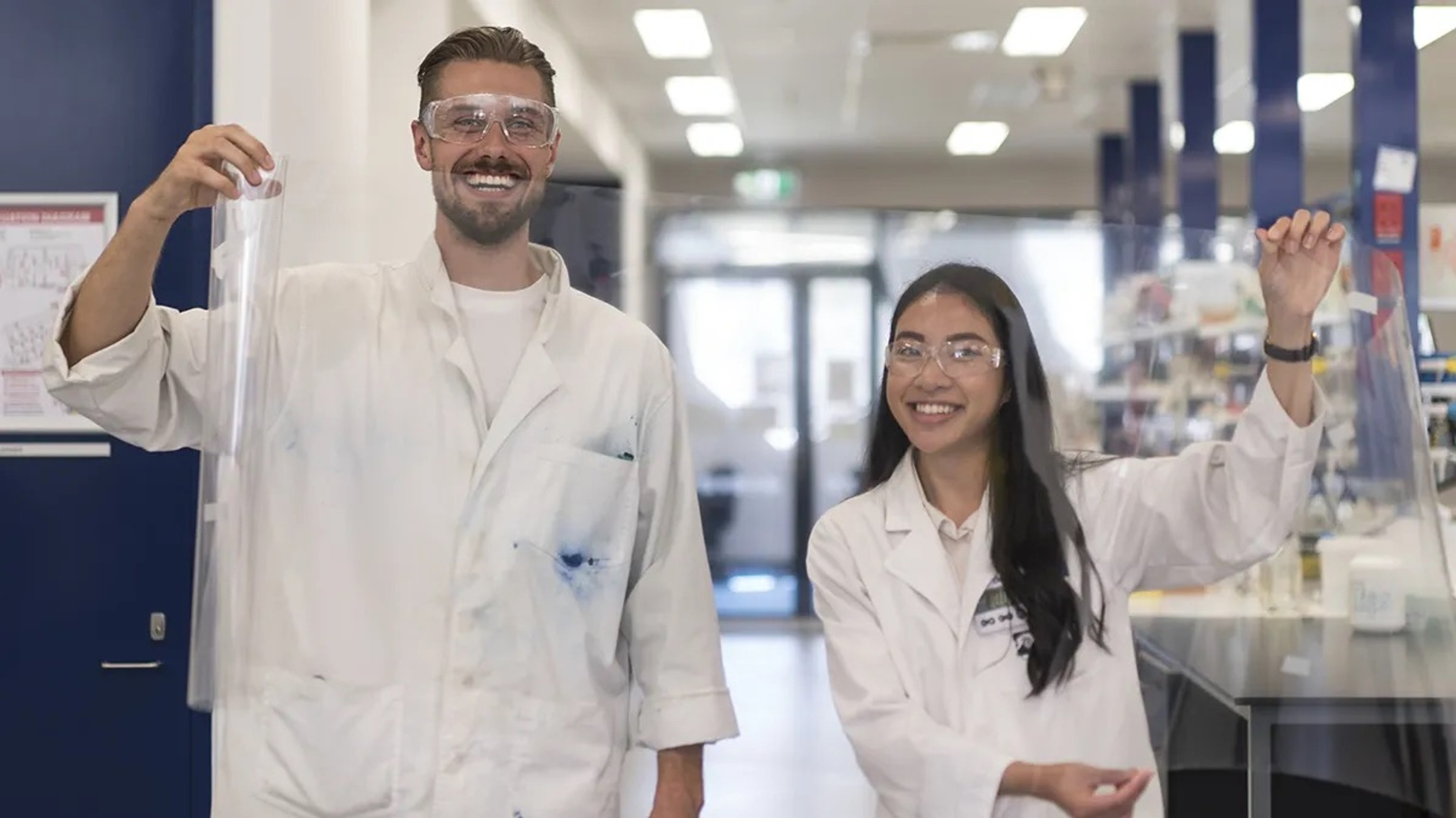 Matt Spence (left) and Vanessa Vongouthi (Right) holding up PET film in a labratory