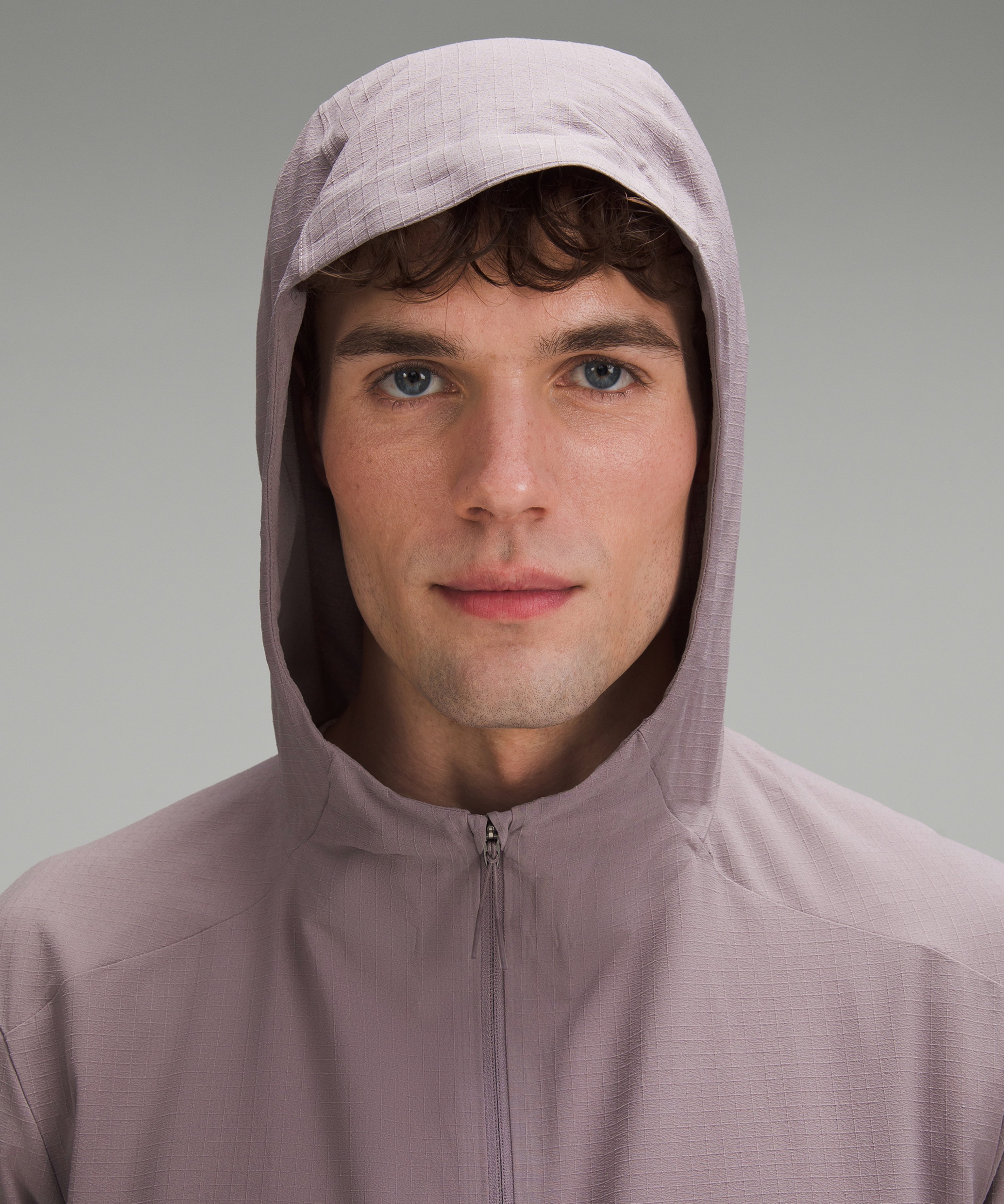 A male model in a quarter-zip hooded jacket made from enzymatically recycled polyester