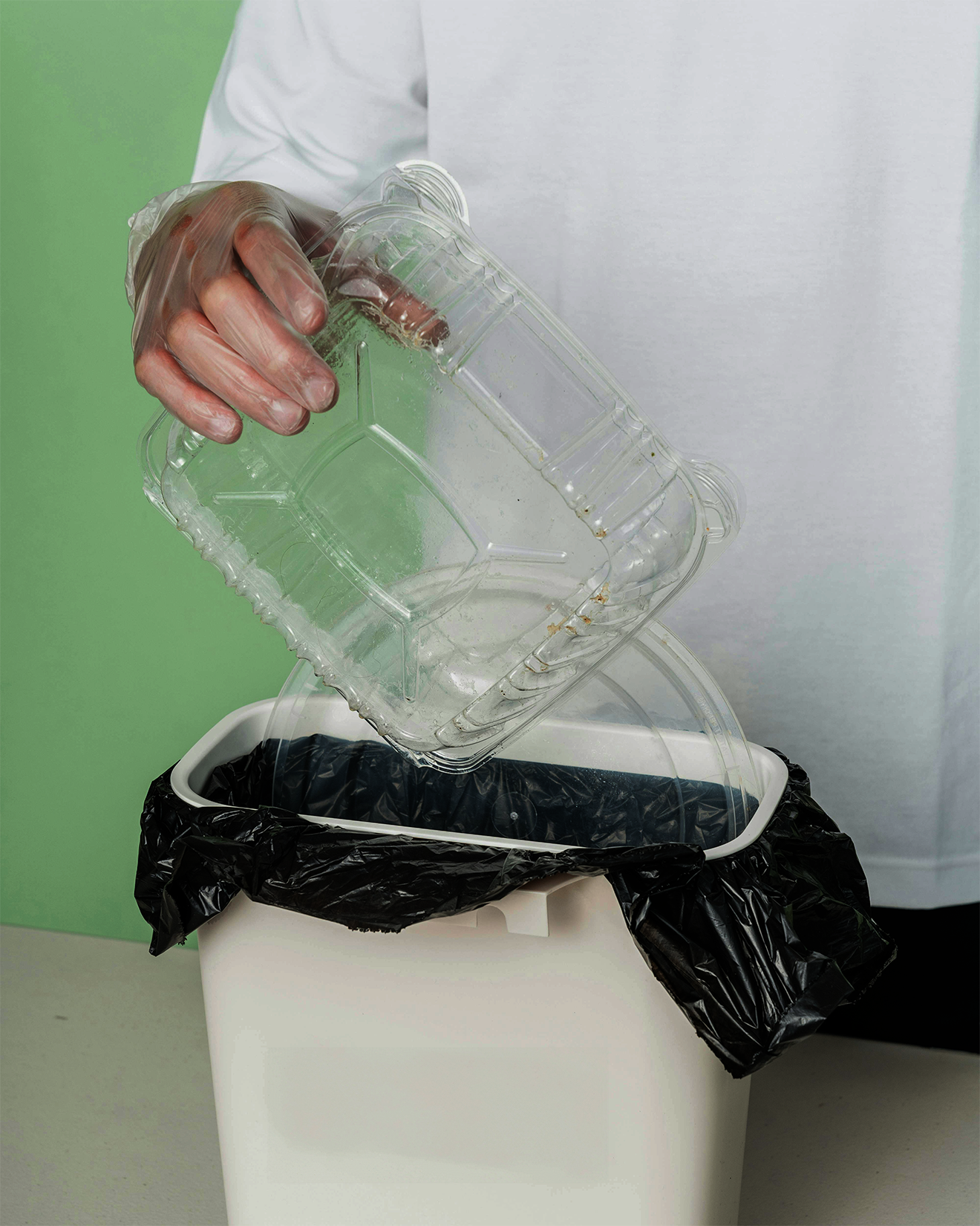 Image of a person putting plastic food packaging into a bin