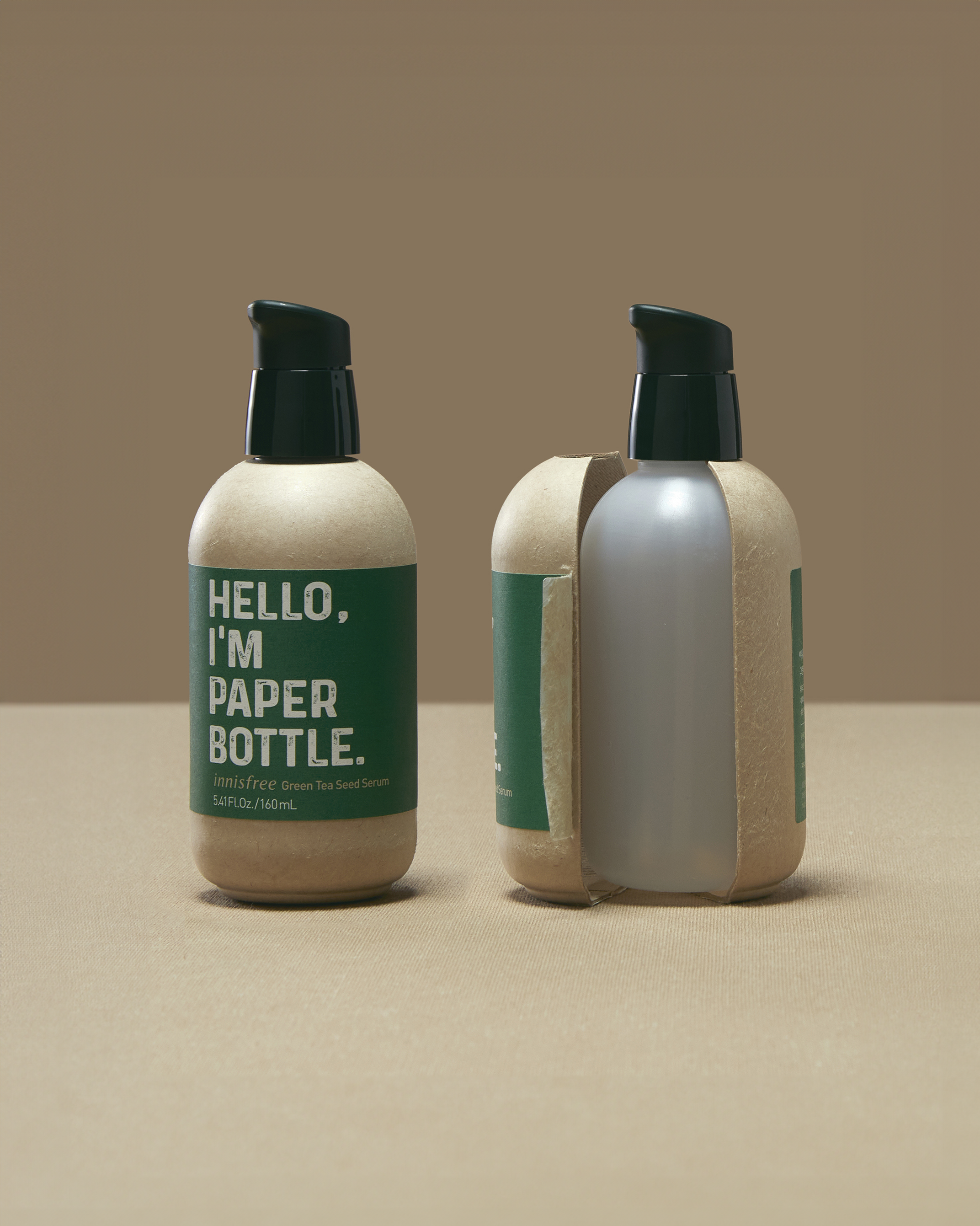 Image of a pump action bottle that says 'Hello, I'm Paper Bottle' on the left. On the right the same bottle is cut open and shows that there is a plastic bottle on the inside.