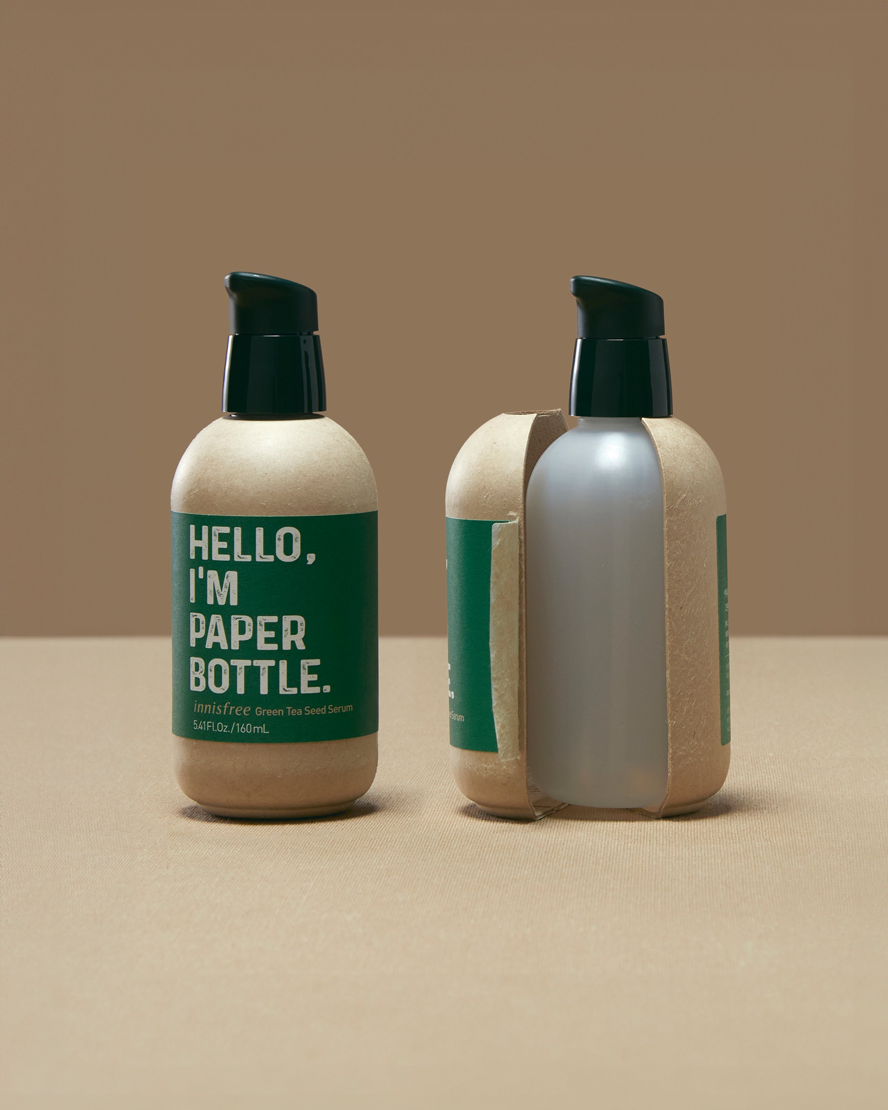Image of a pump action bottle that says 'Hello, I'm Paper Bottle' on the left. On the right the same bottle is cut open and shows that there is a plastic bottle on the inside.