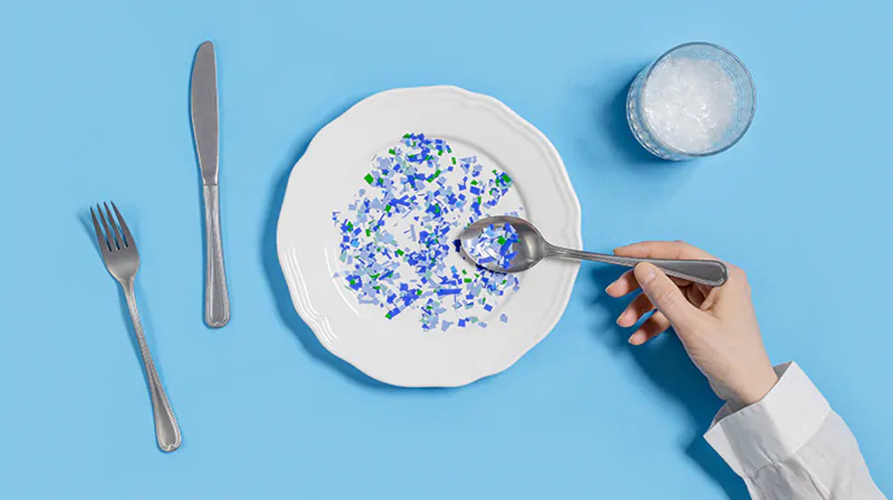 Dinner plate with cutlery and microplastic on the plate and spoon about to be eaten.