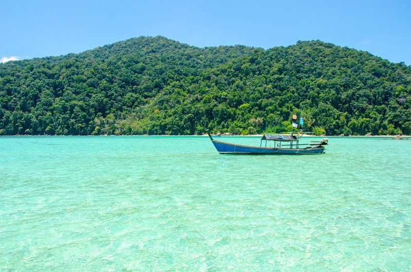 Mer turquoise et paysage idyllique sur l’île Surin avec un bateau traditionnel thaïlandais.