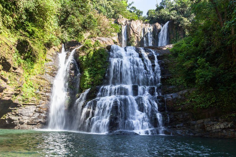 Vue de la magnifique cascade de Nauyaca, entourée par la végétation luxuriante de la forêt tropicale au Costa Rica, avec ses eaux cristallines tombant en plusieurs niveaux.