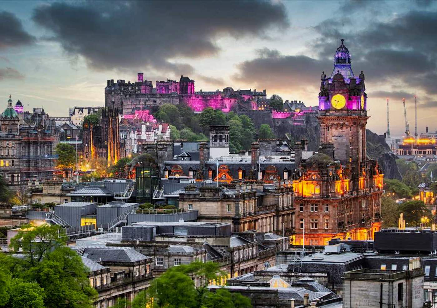 Vue crépusculaire sur Edinburgh Castle illuminé et la Balmoral Clock Tower depuis Calton Hill, dans le centre historique d'Édimbourg en Écosse.