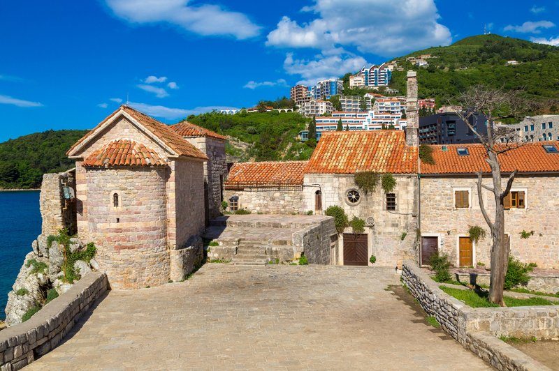 Citadelle de Budva et remparts en pierre avec toits rouges et mer Adriatique