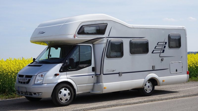 Camping-car moderne stationné à la campagne, symbole de liberté et de vacances en road trip