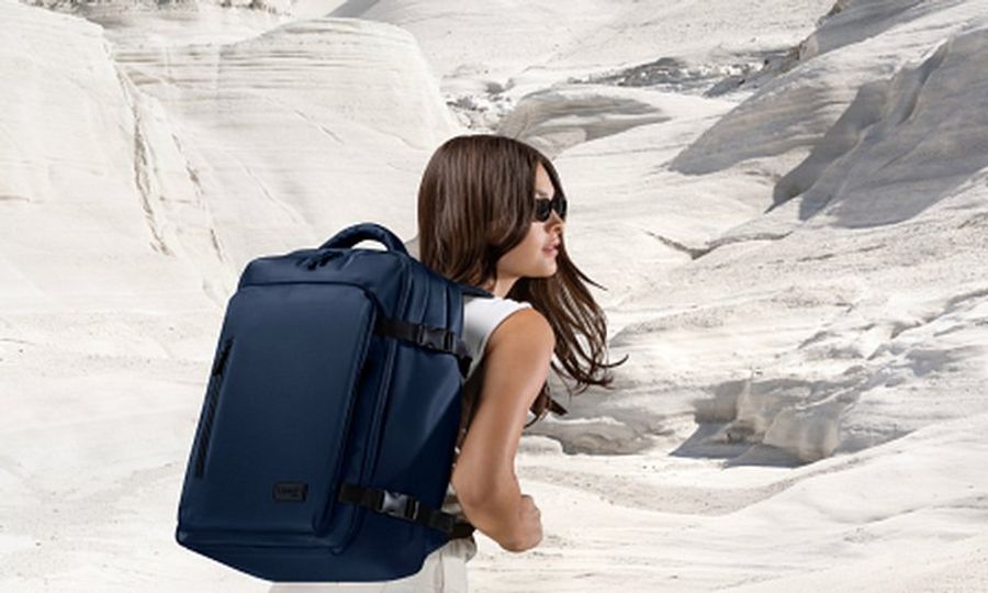 Femme portant un sac à dos de voyage dans un paysage désertique lors d’un road trip